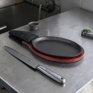 COMAL OVALADO DE HIERRO FUNDIDO 9 1/4 X 7 PG CON BASE DE MADERA, CON MANGO Y PROTECTOR DE TELA NEGRO (PRECIO POR 12 PIEZAS)